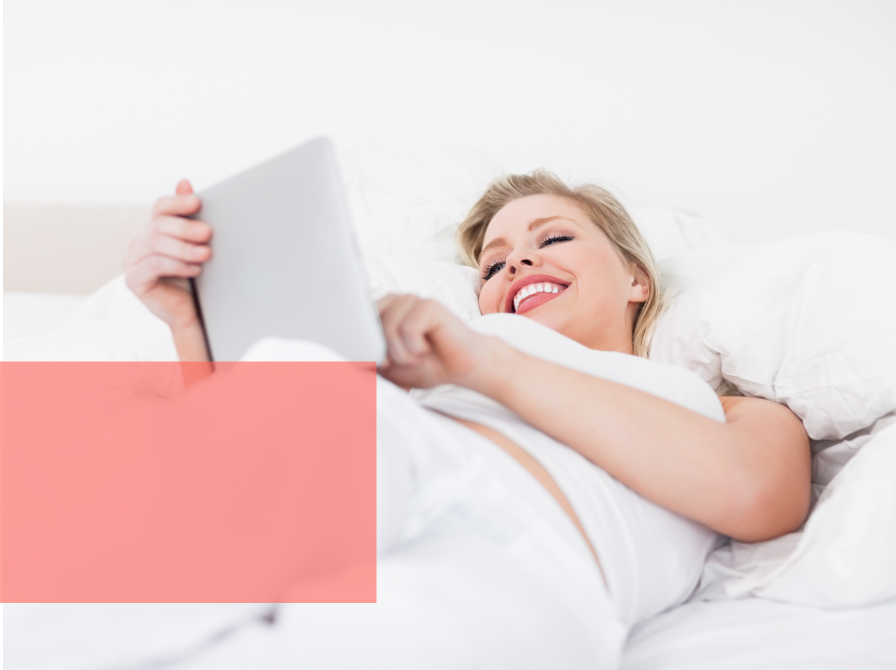 Kvinde læser og grinder i seng